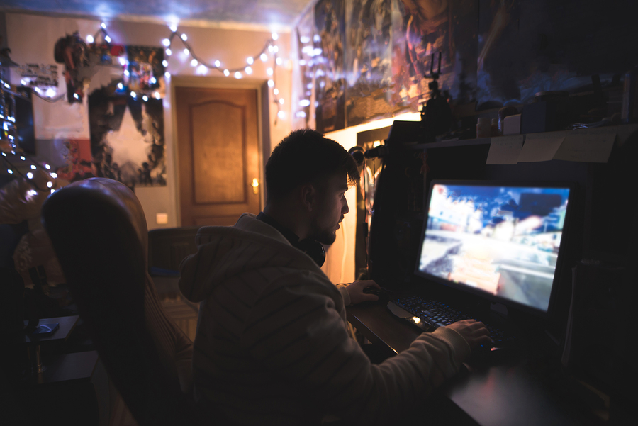 Gamer With Beard Plays Games On A Home Computer. A Young Man Sit