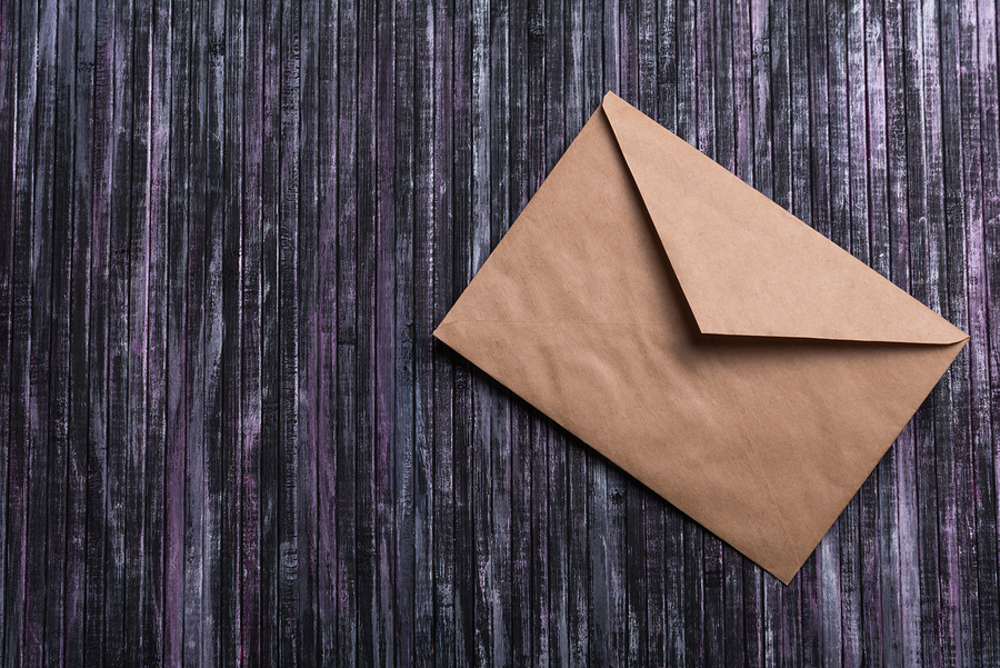 Envelope of Kraft paper. Love letter envelope. Wooden background.