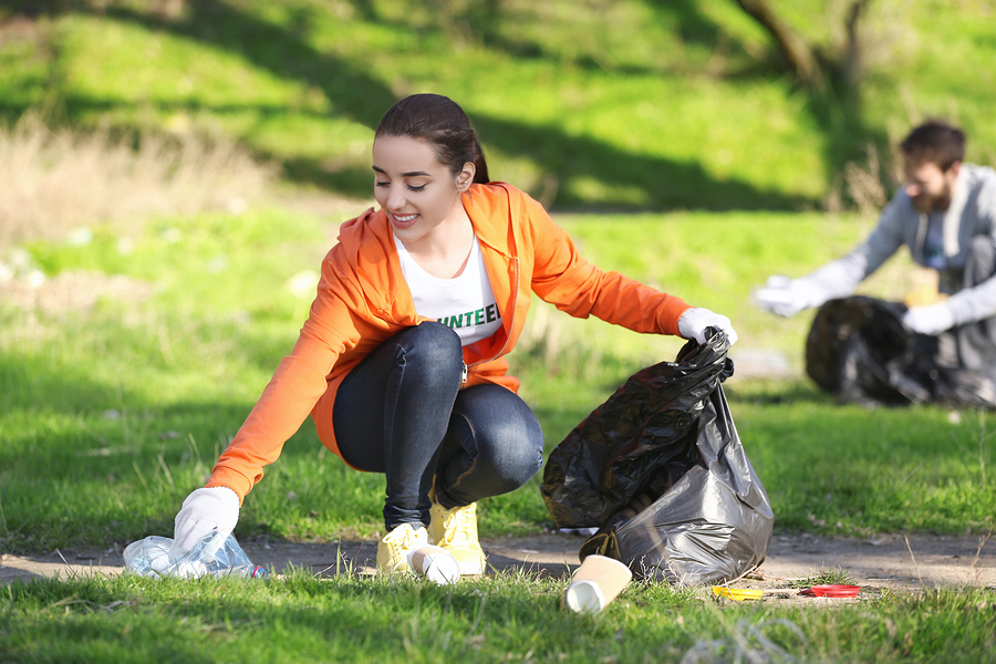 Volunteer picking up litter in park after bonfire night Volunteer picking up litter in park after bonfire night