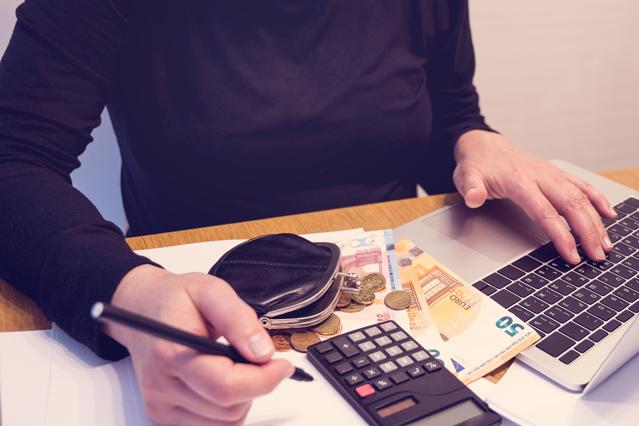 Budget planing concept. Top view of a woman writing categories of expences for her budget to create a plan for shopping and savings. Family budget concept. Reasonable income and expence. Copy space