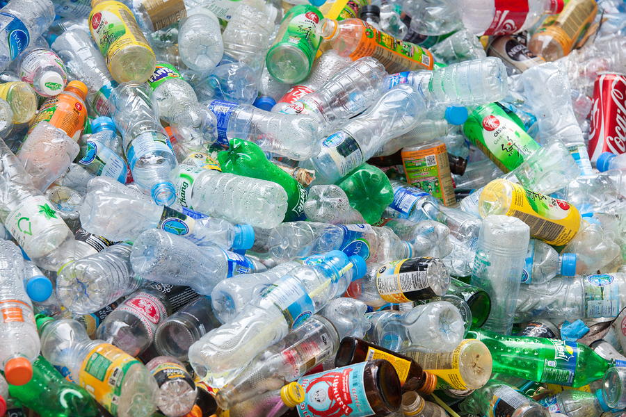 Close-up view plastic bottles of various drinks in the yard of a company specializing in ecological treatments. Large heap of plastic bottles and containers for recycling.