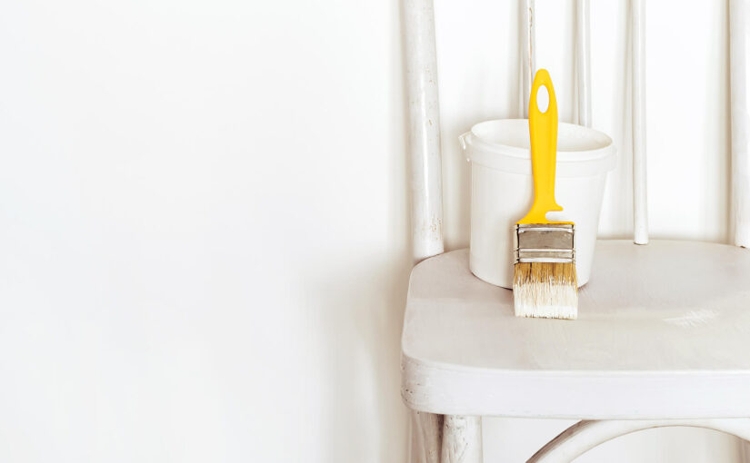 A paint brush sitting atop a chair.