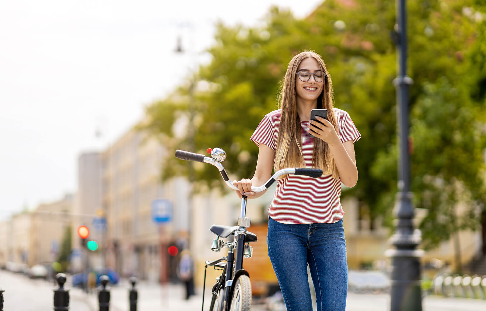 A woman on her bike while holding her phone.