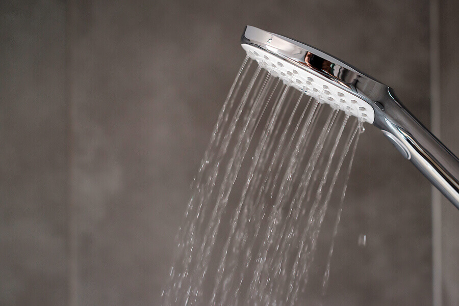 Water flowing from shower, close up. Modern bathroom interior.