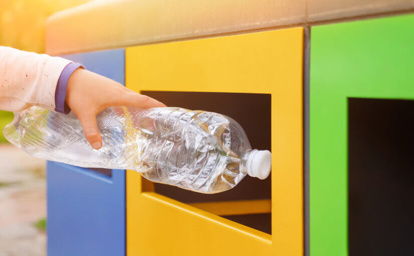 Close up hand throwing plastic bottle recycling container garbage sorting rubbish collection bin.