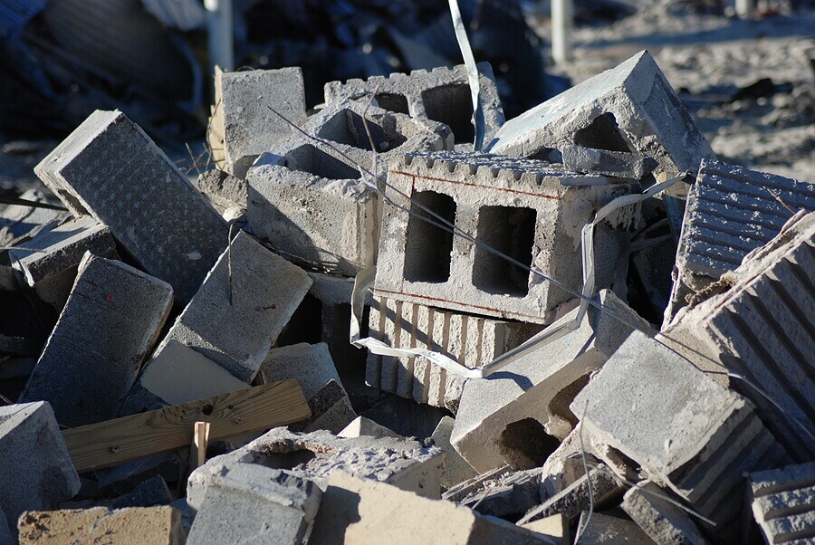 Cinder blocks and other refuse in a pile of material on a demolition site.